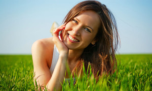 Happy young woman laying in grass